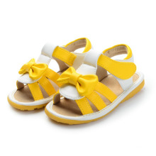 Sandálias de bebê amarelo com uma linda arco